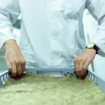 Cientista de jaleco manipula amostras em um laboratório voltado a pesquisas sustentáveis.