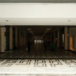 Corredor de um shopping center moderno, com lojas e pessoas circulando.