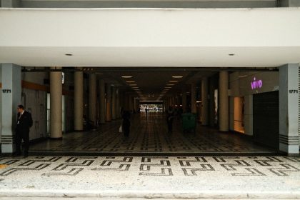 Corredor de um shopping center moderno, com lojas e pessoas circulando.