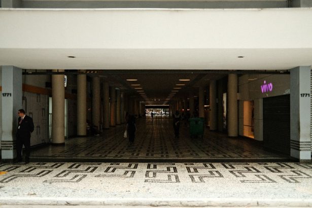 Corredor de um shopping center moderno, com lojas e pessoas circulando.