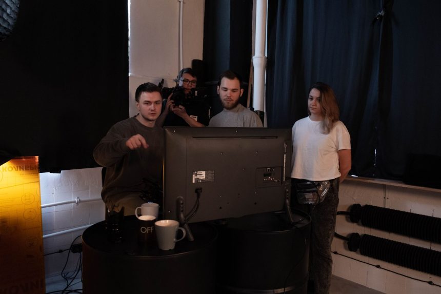 Equipe colaborando em um projeto de produção de vídeo dentro de um estúdio audiovisual